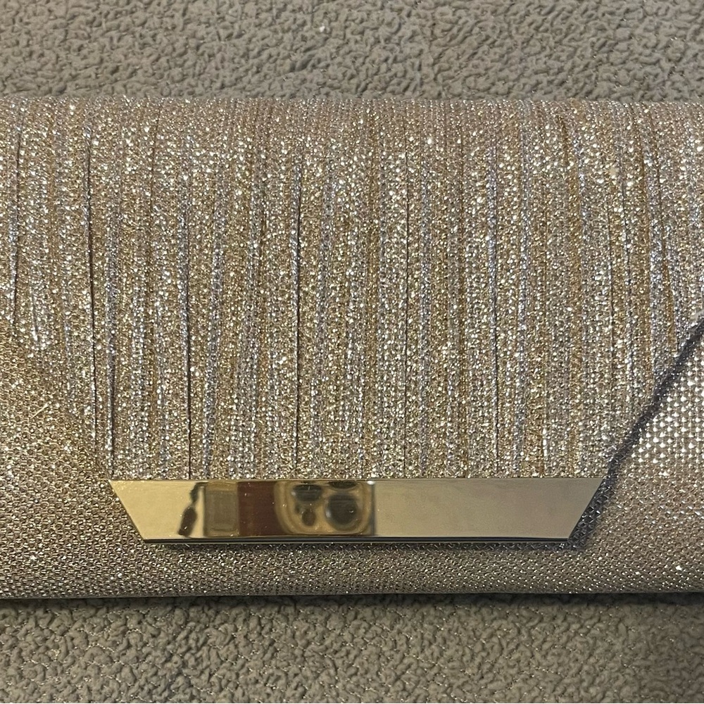Champagne dazzling embellished clutch with shoulder chain included.